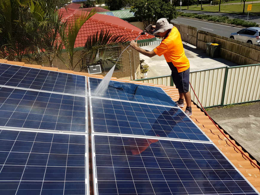 Rinsing-down-the-solar-panels-after-roof-washing
